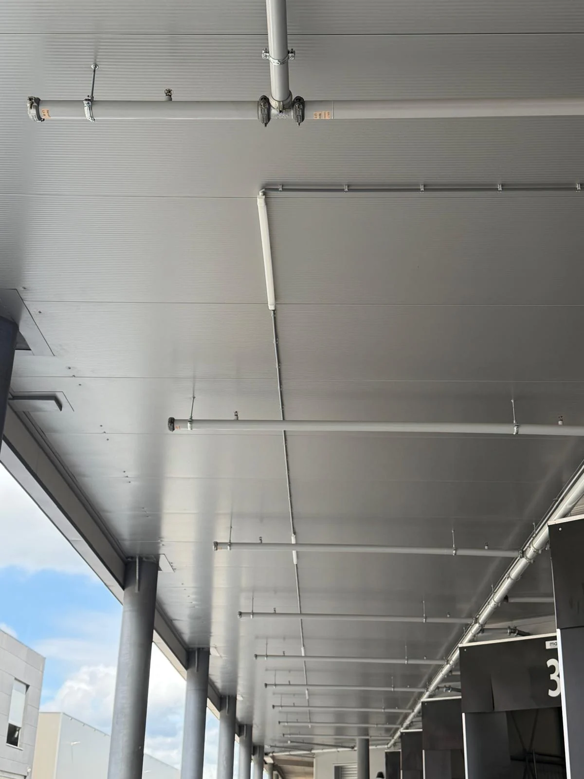 Leidingwerk en buitenverlichting onder overkapping